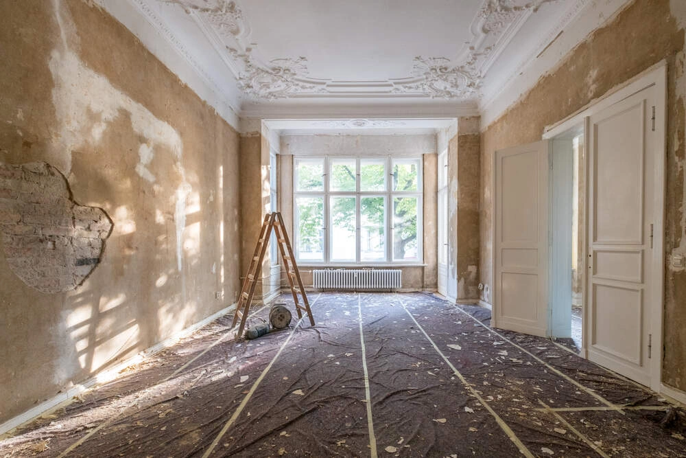 renovation concept - ladder in empty apartment room during restoration or refurbishment